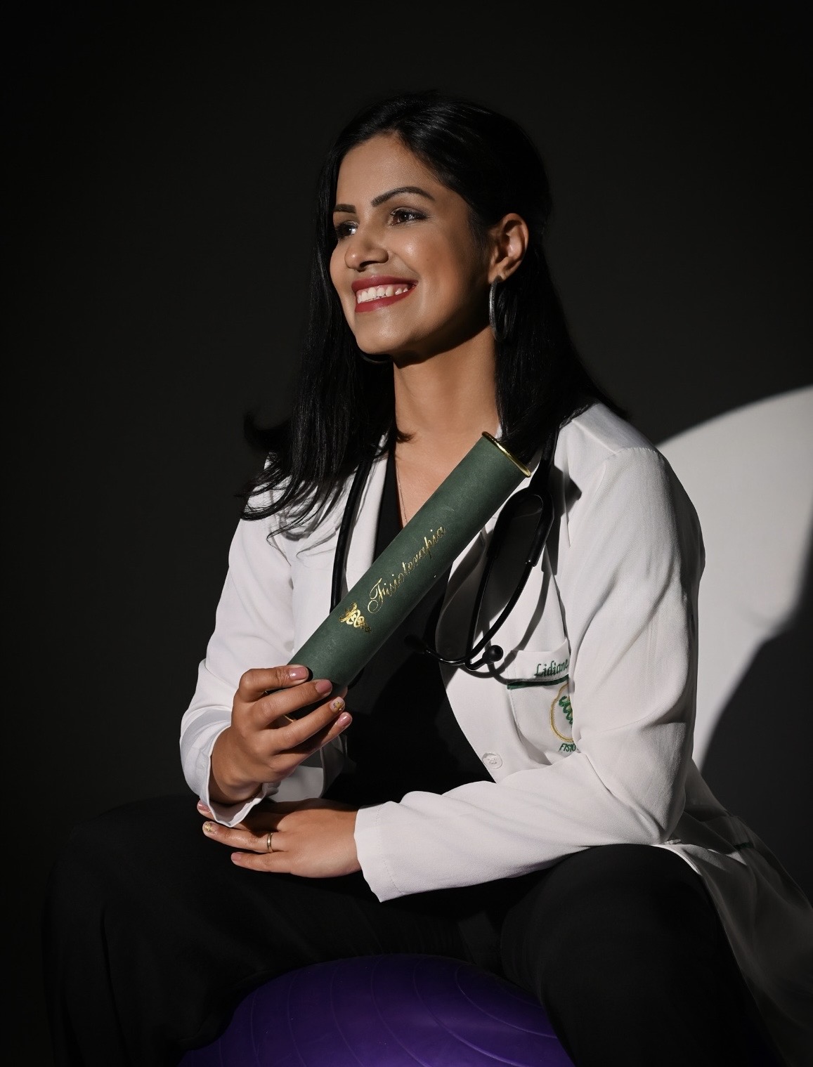 Lidiane de Oliveira segurando o diploma de Fisioterapia na formatura